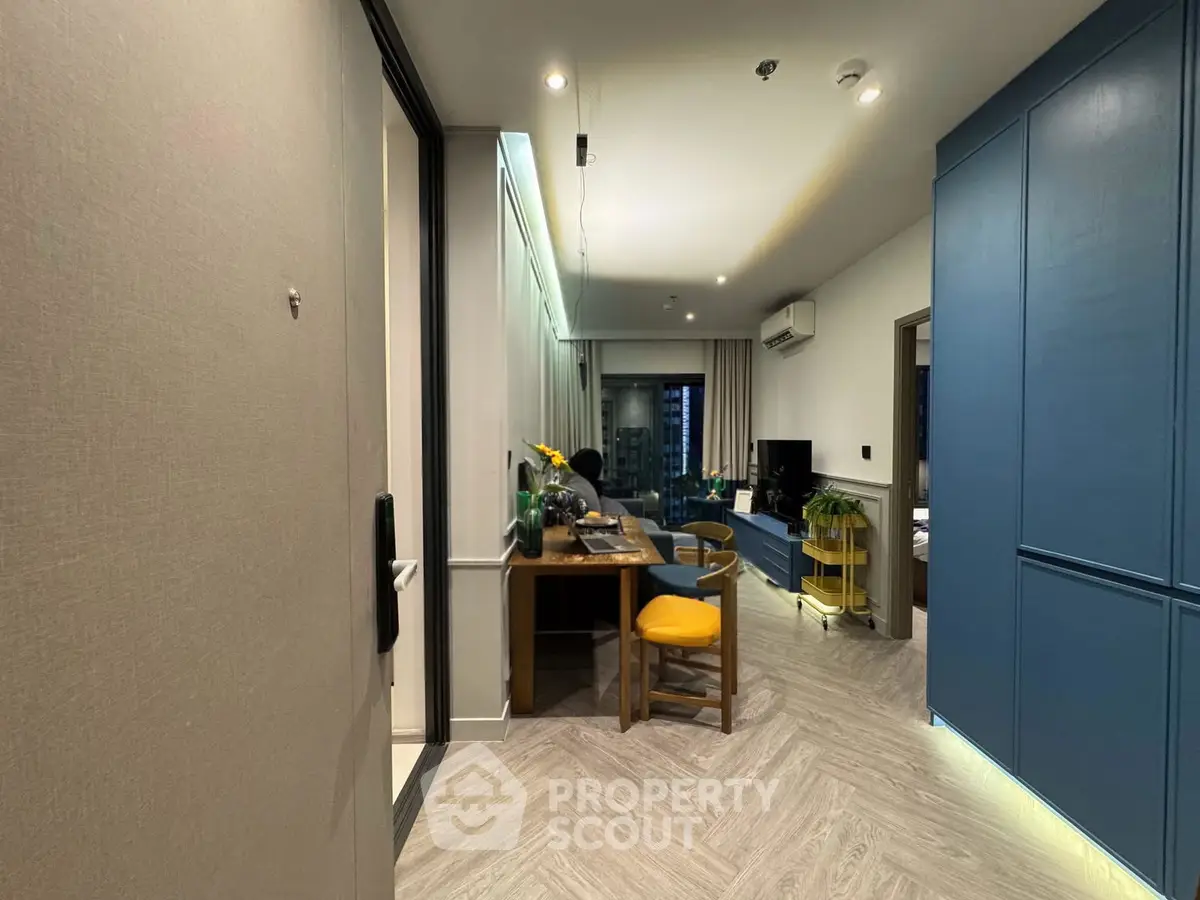 Modern living room with stylish decor and open layout, featuring a cozy workspace and vibrant accents.