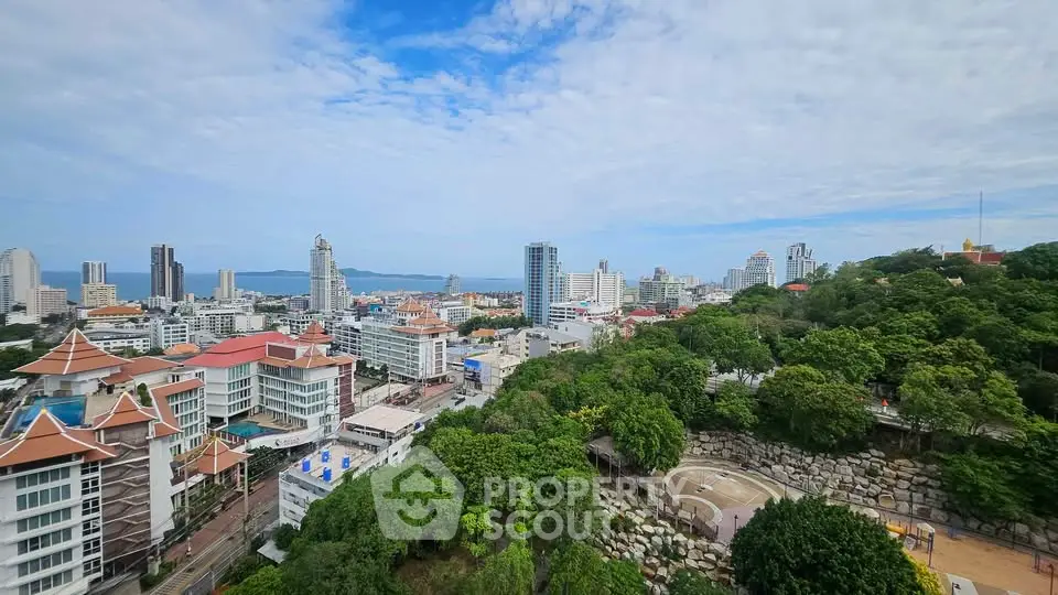 Stunning cityscape view with lush greenery and modern buildings under a clear blue sky.