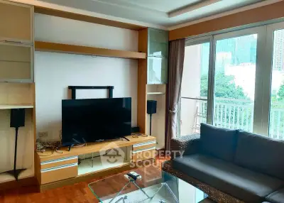Spacious living room with modern entertainment setup and balcony view.