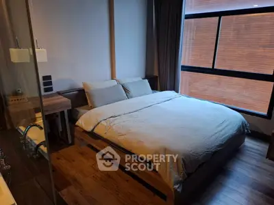 Modern bedroom with wooden flooring and large window for natural light