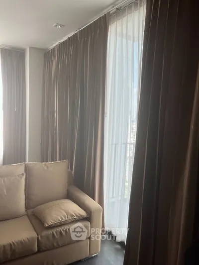 Cozy living room with elegant curtains and plush sofa, perfect for relaxation.