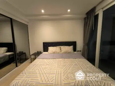 Modern bedroom with mirrored closet and stylish bedding in a cozy apartment.