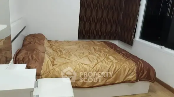 Cozy bedroom with modern decor and large window for natural light.