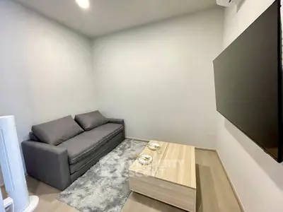 Cozy living room with modern sofa and wall-mounted TV, perfect for relaxation.