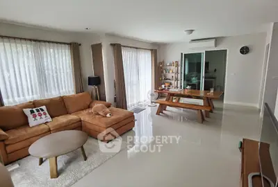 Spacious living room with modern furniture and dining area, perfect for family gatherings.
