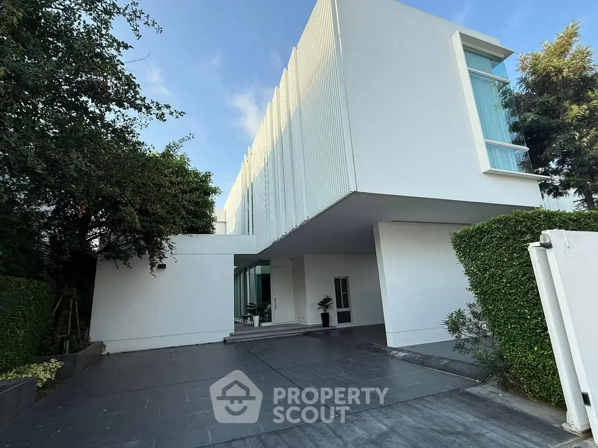 Modern minimalist white building with sleek design and lush greenery
