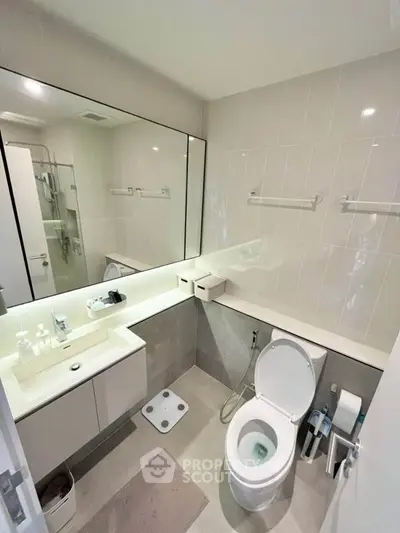 Modern bathroom with sleek fixtures and large mirror in contemporary apartment.