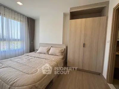 Modern bedroom with cozy bed and large wardrobe in bright apartment