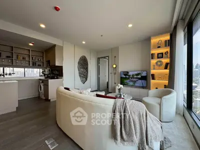 Modern living room with open kitchen and city view, featuring elegant decor and cozy seating.