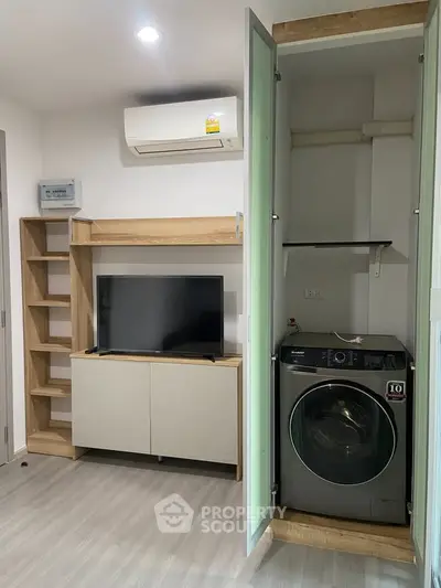 Modern living room with built-in washer and TV unit, featuring sleek storage solutions.