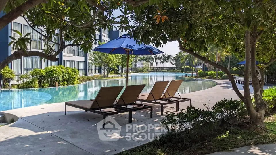 Luxurious poolside area with sun loungers and umbrellas in a modern residential complex.