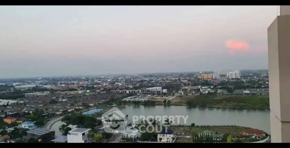 Stunning panoramic cityscape view from high-rise apartment balcony at sunset.