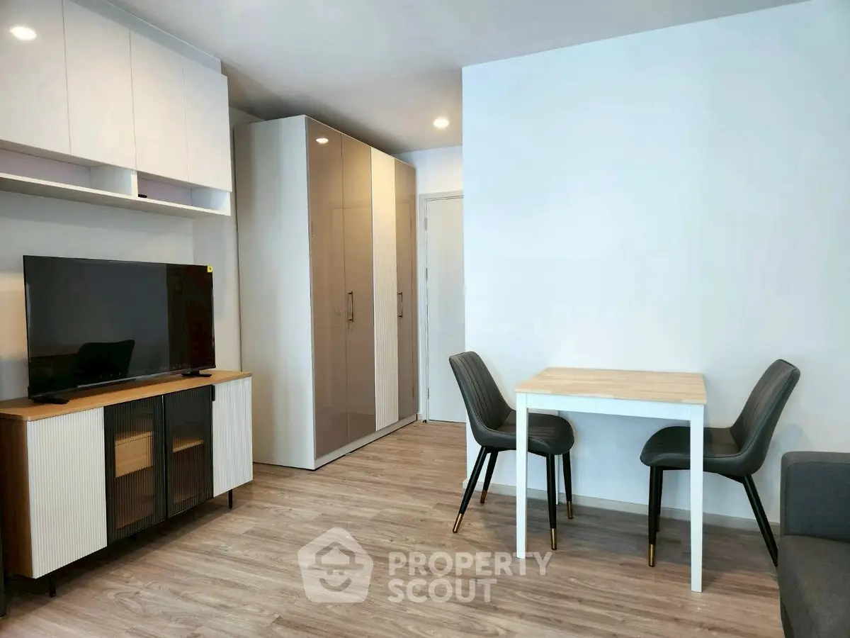 Modern living room with sleek furniture and TV unit in a cozy apartment.
