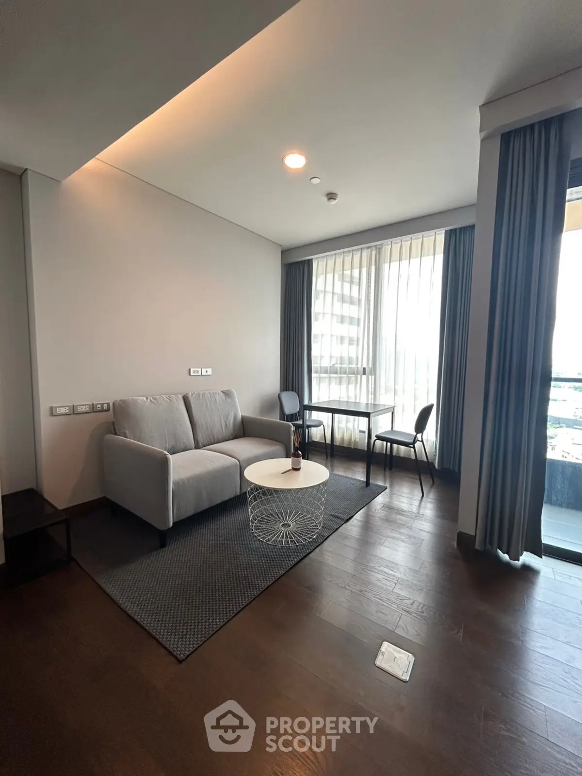 Modern living room with cozy sofa and large window offering city view