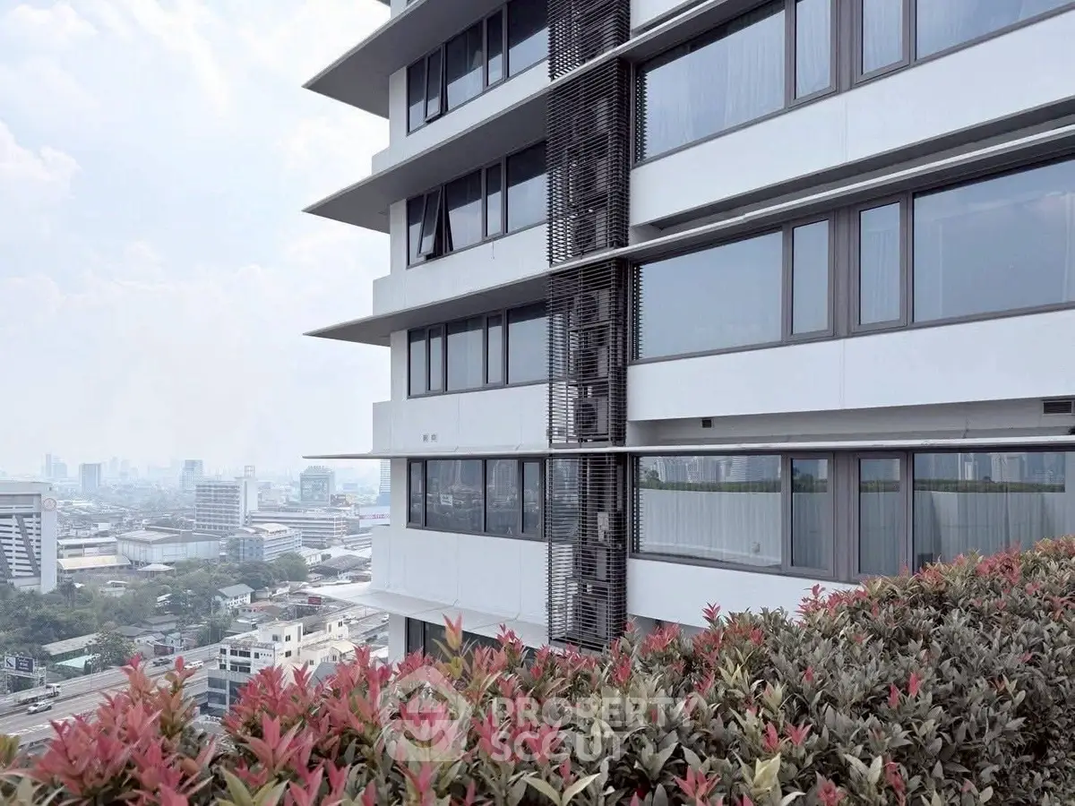 Modern high-rise building with panoramic city view and lush greenery