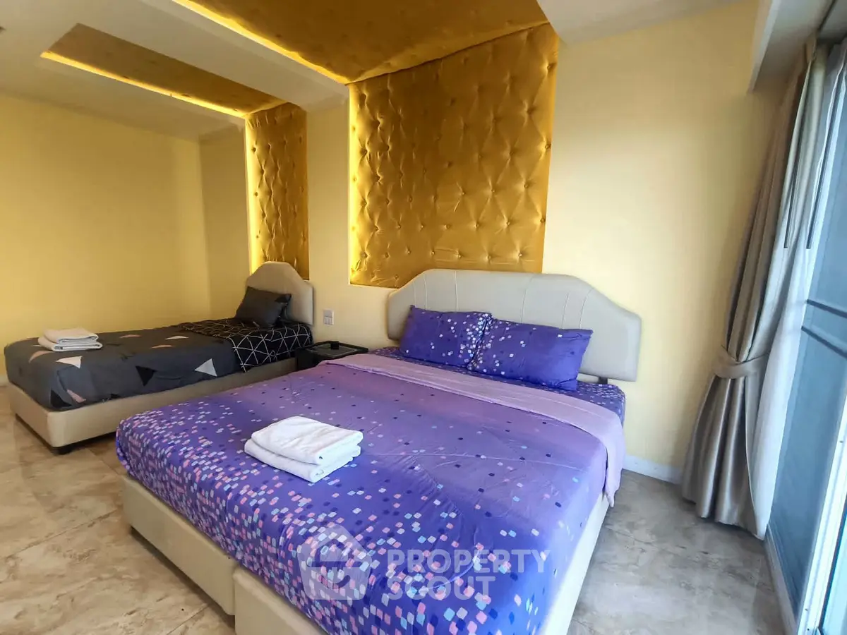 Luxurious bedroom with elegant lighting and modern decor, featuring two comfortable beds and stylish furnishings.
