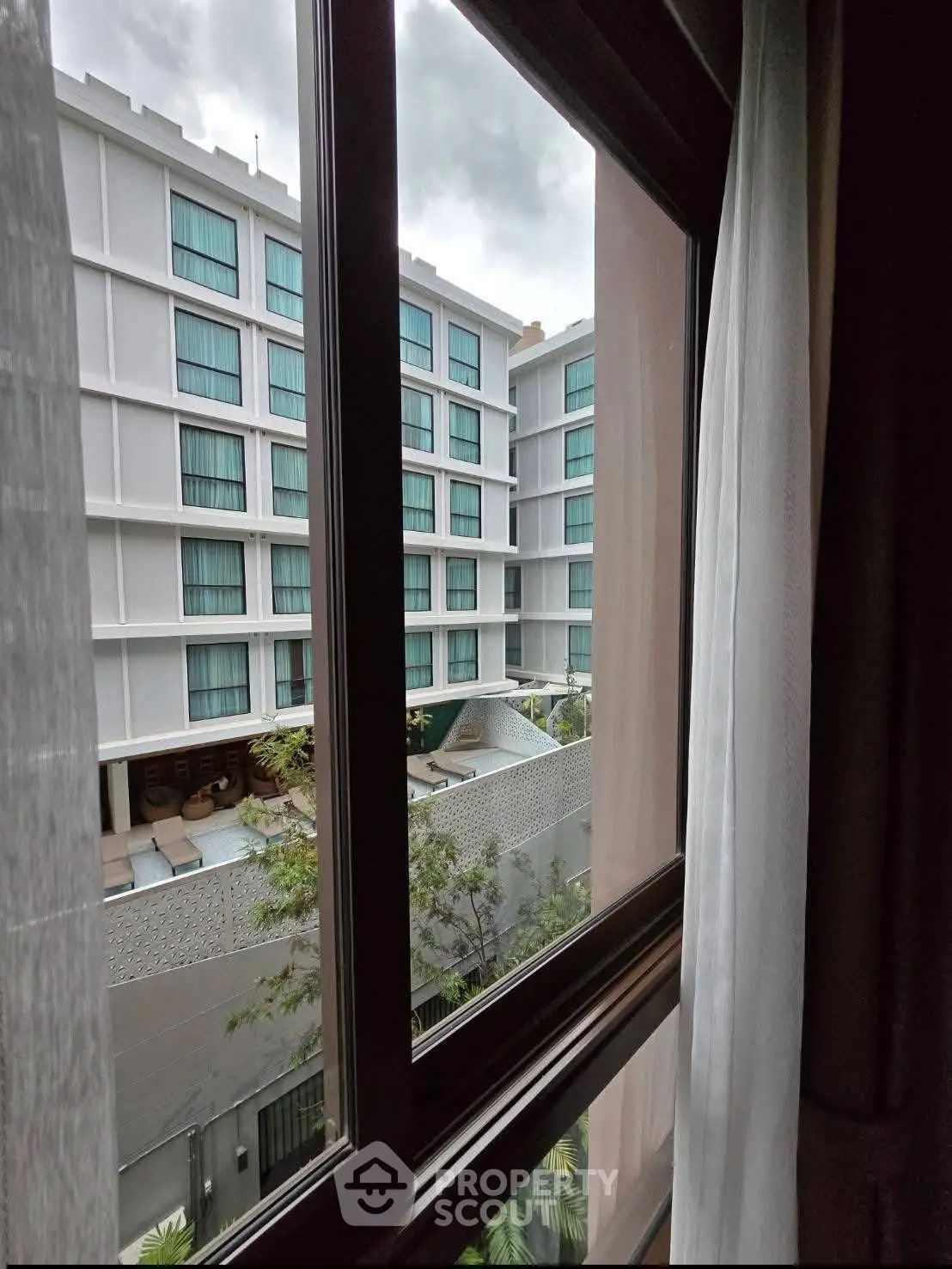 Modern hotel view from window overlooking pool and courtyard, perfect for urban living.
