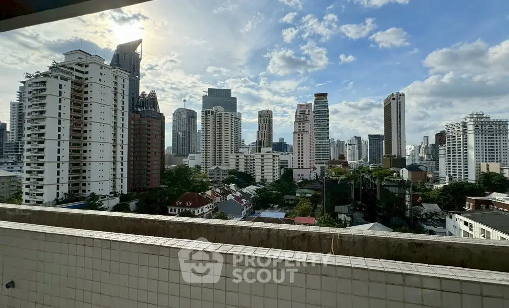 Stunning cityscape view from a high-rise balcony showcasing modern skyscrapers under a clear blue sky.