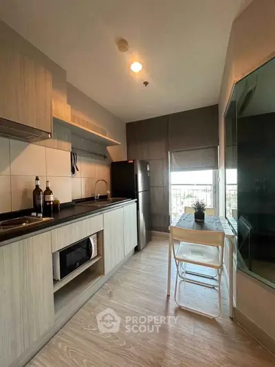 Modern kitchen with sleek cabinetry and compact dining area, perfect for urban living.
