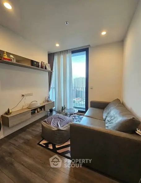 Cozy modern living room with large window and stylish furniture, offering a comfortable urban lifestyle.