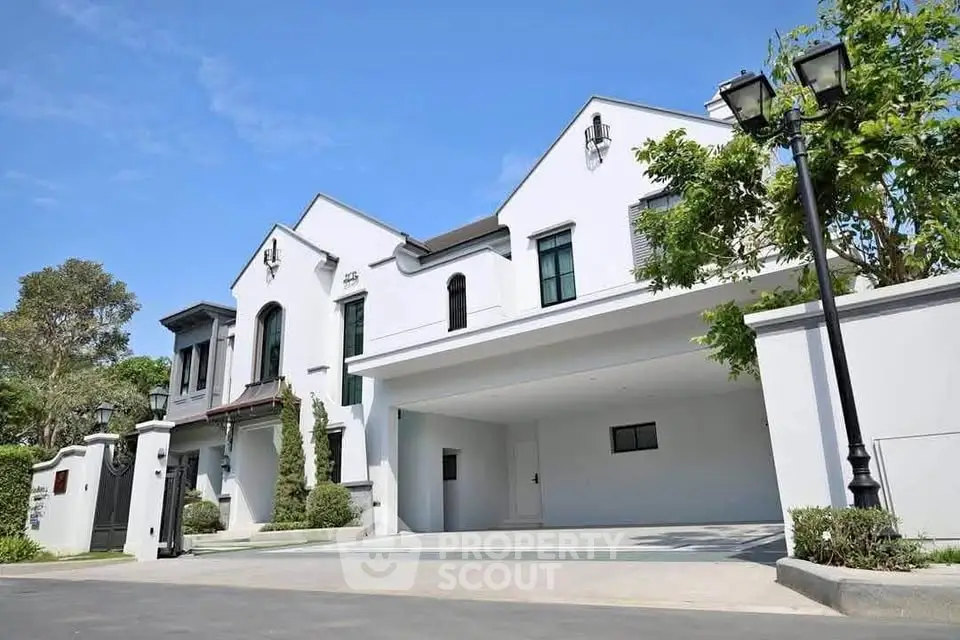 Stunning modern white house with spacious driveway and lush greenery, perfect for luxury living.