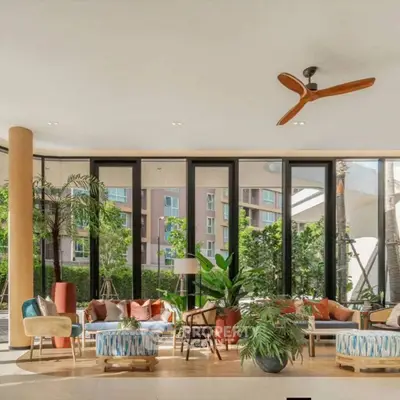 Luxurious modern living room with large windows and stylish decor, offering a serene garden view.