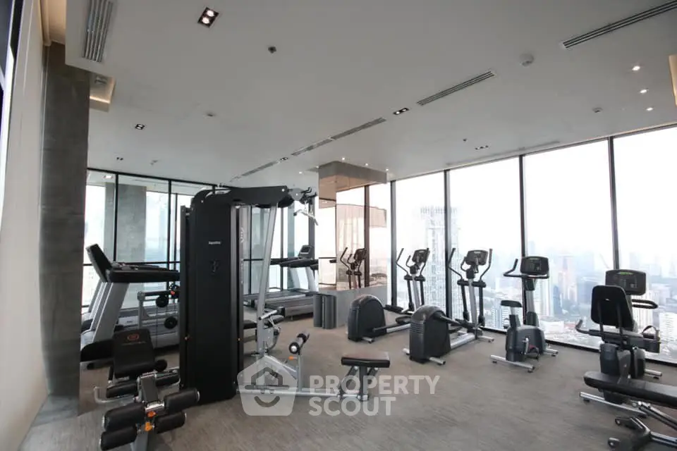 Modern high-rise gym with panoramic city views and state-of-the-art fitness equipment.