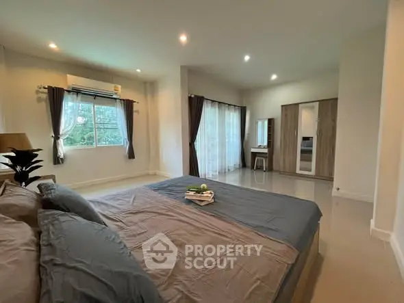 Spacious bedroom with large windows and modern decor