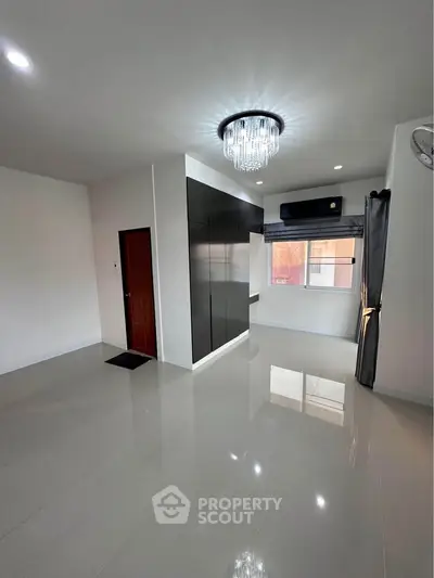 Spacious modern living room with elegant chandelier and large window
