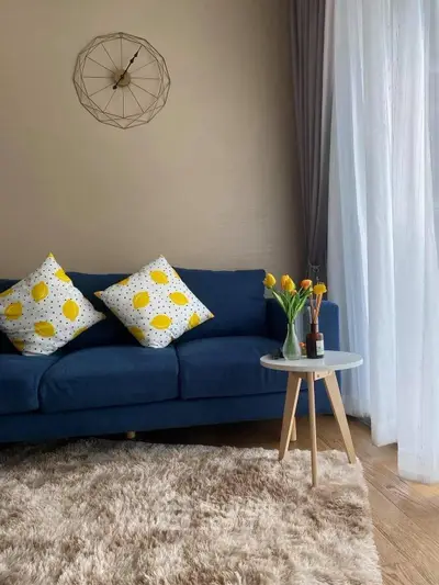 Stylish living room with blue sofa, yellow accents, and cozy decor