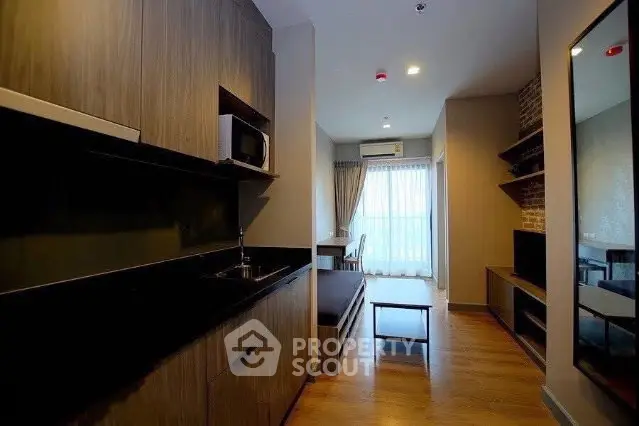 Modern apartment interior with sleek kitchen and cozy living area, featuring wood accents and natural light.