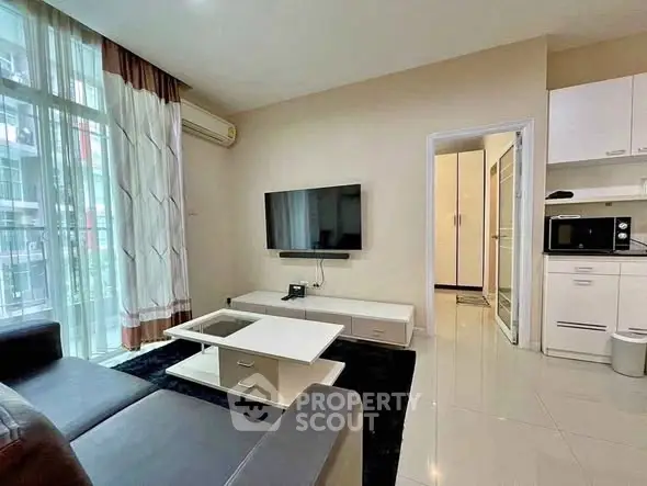 Modern living room with sleek furniture and open kitchen layout, perfect for urban living.