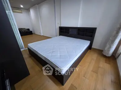 Spacious bedroom with modern bed frame and wooden flooring