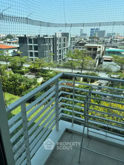 Charming balcony with lush garden view in urban setting, perfect for relaxation and enjoying cityscape.