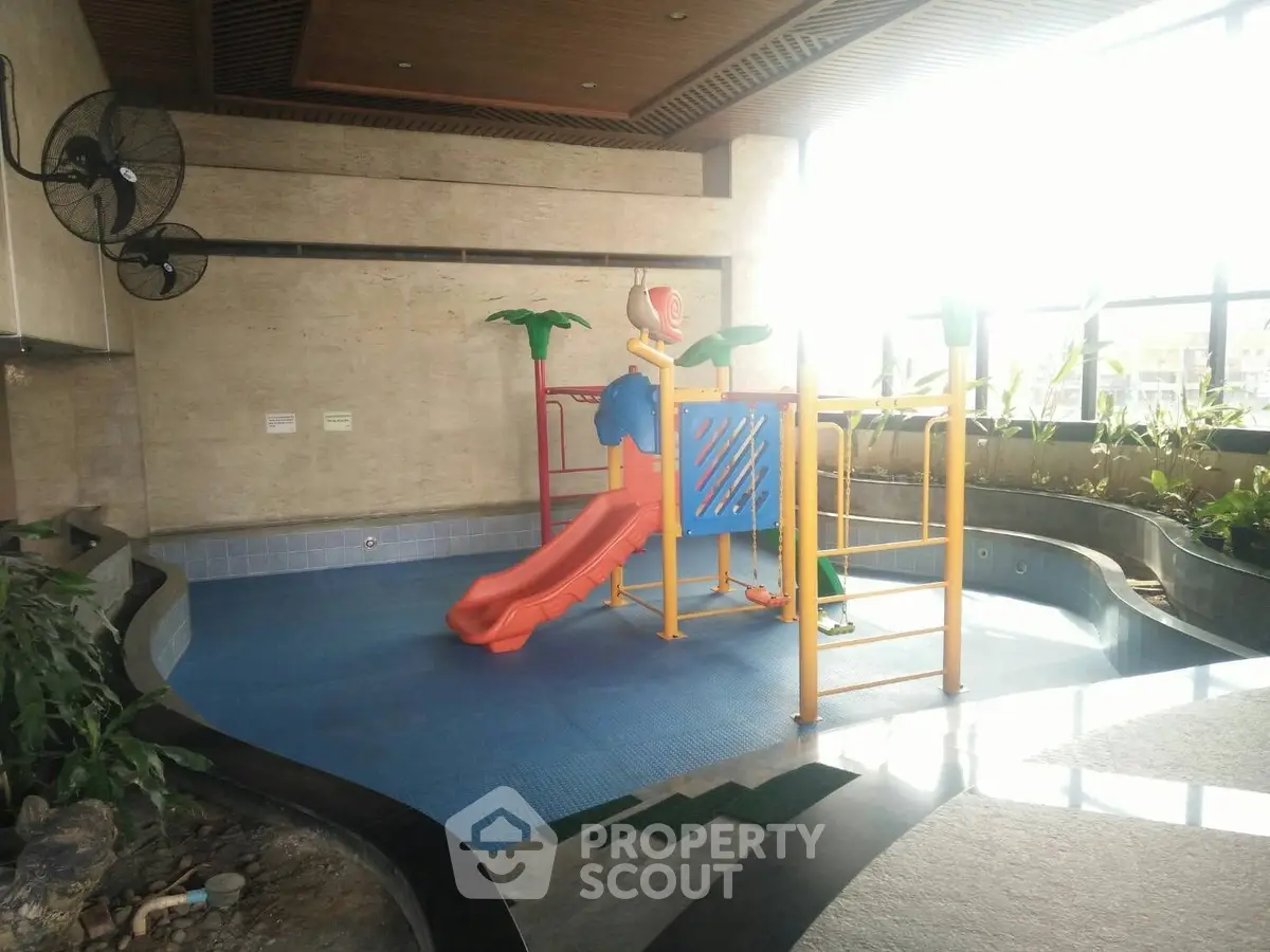 Indoor children's play area with slide and climbing structure in modern building.