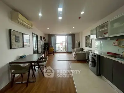 Spacious modern living room with open kitchen and balcony view
