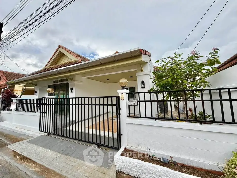 Charming single-story house with gated entrance and lush garden, perfect for family living.
