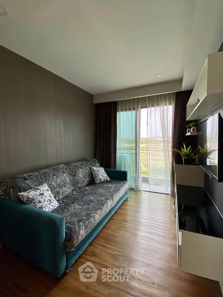 Cozy living room with modern decor and large window offering scenic views.