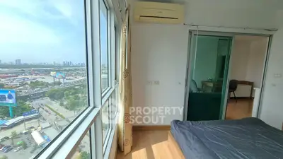 Spacious bedroom with city view and modern furnishings in high-rise apartment