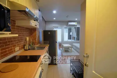 Modern apartment kitchen with open layout leading to cozy living room