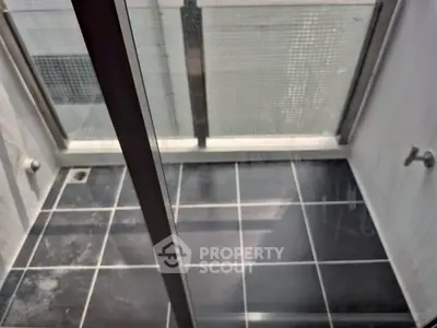 Modern bathroom with sleek black tiles and glass shower enclosure