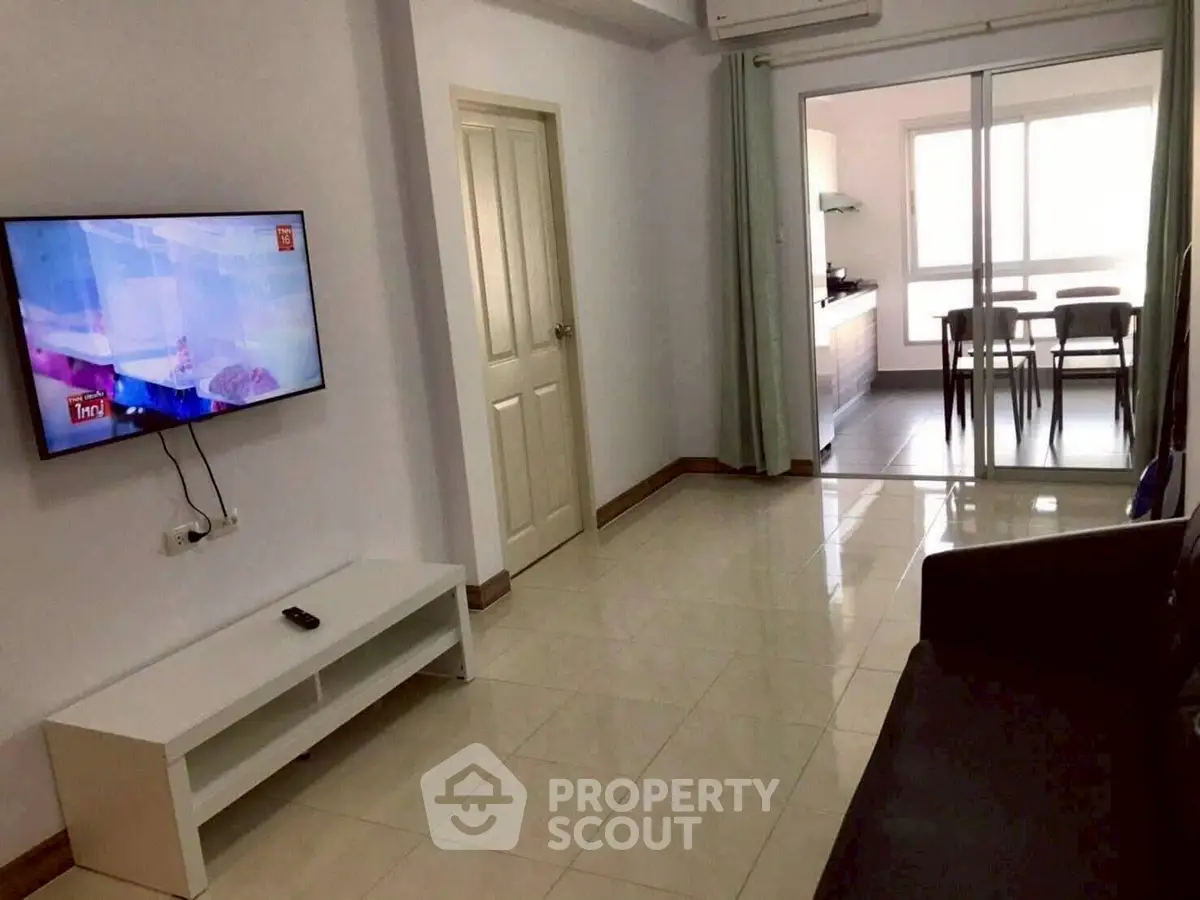 Modern living room with wall-mounted TV and open kitchen layout