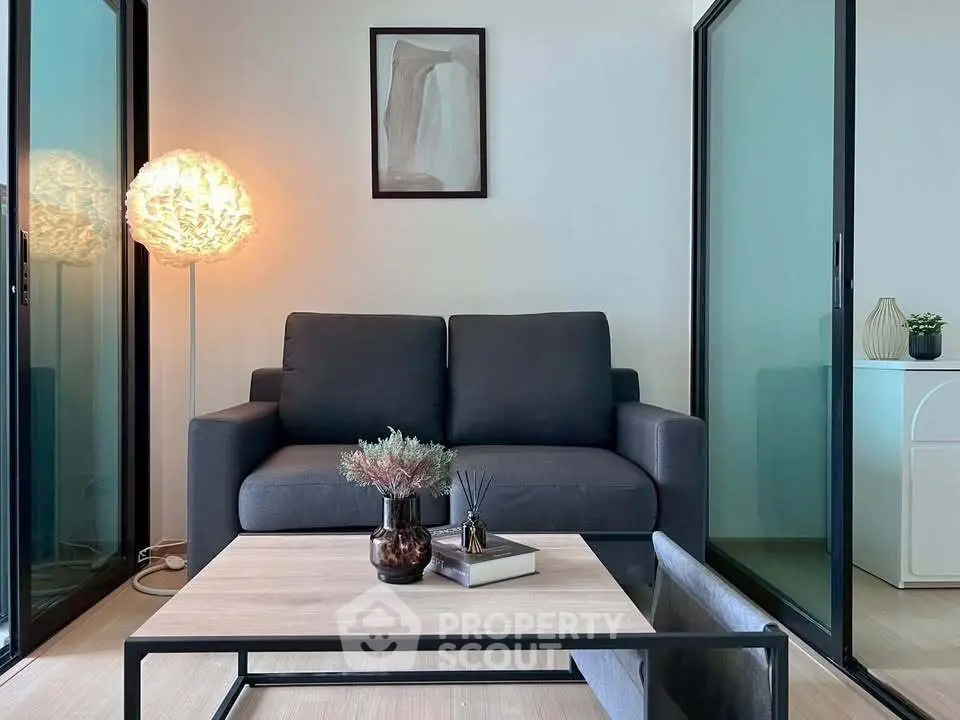 Modern living room with sleek black sofa and stylish decor, perfect for urban living.