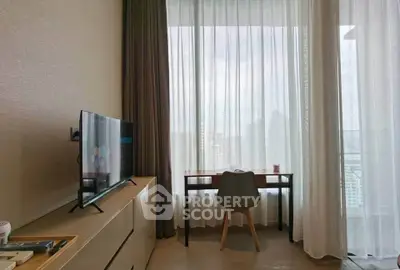 Modern living room with city view, featuring a sleek TV and stylish desk by the window.