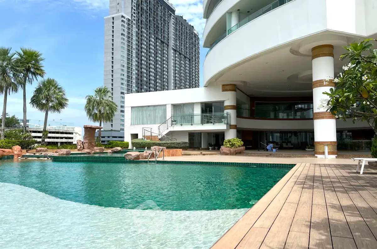 Luxurious modern building with stunning pool and palm trees, perfect for upscale living.