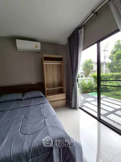 Modern bedroom with large window and garden view, featuring sleek design and natural light.