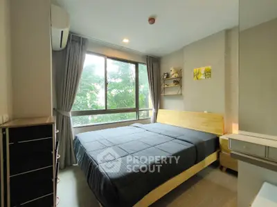 Modern bedroom with large window and stylish decor, featuring a comfortable bed and natural light.
