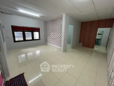Spacious unfurnished room with tiled flooring and patterned accent wall