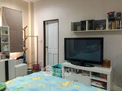 Cozy bedroom with TV and organized storage, perfect for relaxation and entertainment.