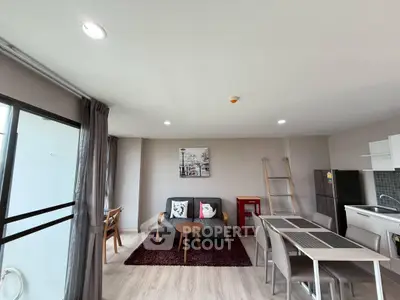 Modern living room with open kitchen, stylish decor, and ample natural light in a contemporary apartment.